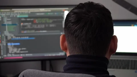 Young man coding on computer at work desk, programmer working late, IT Stock Footage 326002916