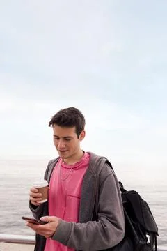 Young man with a coffee using a mobile phone Stock Photos