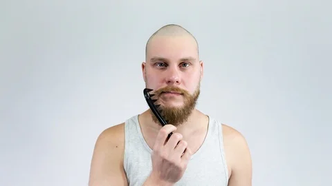 Young man combing his thick red beard big black comb. Stock Footage 122005457