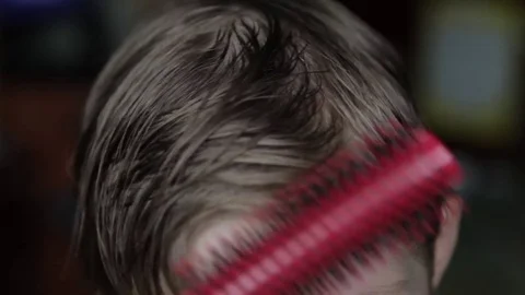 A young man combs his short hair with a comb. Stock Footage 76608364