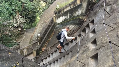 Young man comes down the stairs in the stone ancient temple Mulkirigala Stock Footage 71608631