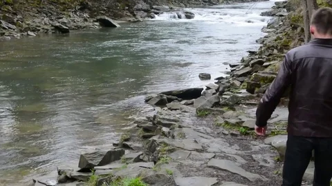 A young man comes to a mountain river Video stock 83431665