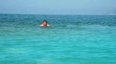 Young man comes out of the sea after swimming Stock-Footage 64515519