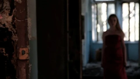 Young man comes into the room, while young beautiful woman in red long dress Stock Footage 89348054