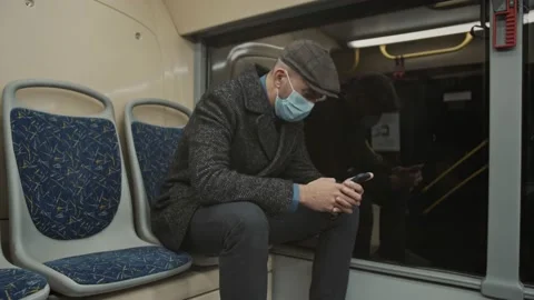 Young man is Coming back late from work during COVID-19 using mobile phone in Stock Footage 168224848
