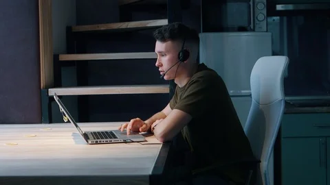 Young man communicates with the client, answering the call. Home office concept Stock Footage 103861954