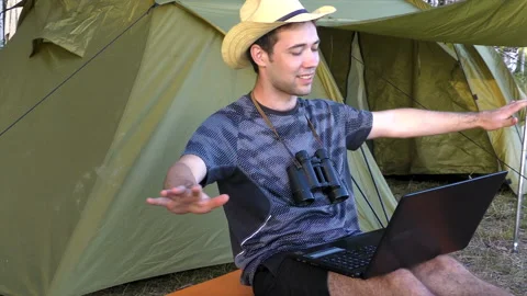 The young man communicates via the Internet on the laptop and holds his thumb up Stock Footage 93447493