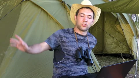 The young man communicates via the Internet on the laptop, gesturing with hands Stock Footage 93447586