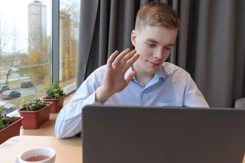 A young man communicates online through a laptop. Stock Photos