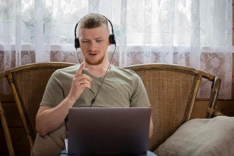 A young man communicates with relatives via video conferencing using a laptop. Foto stock