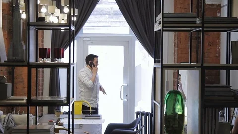 Young man communicates using mobile phone in Bricks wall office. Stock Footage 78684427