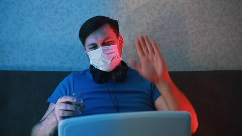 A young man communicates via video calling on a laptop and drinks alcohol. 스톡 동영상 129751011