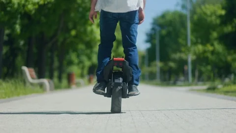 Young man commuting with ease on one-wheel electric vehicle Stock Footage 308657789
