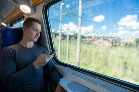 Young man Commuting On Train Using Mobile Phone Stock Photos