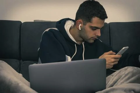 Young man with computer, mobile phone and headphones at home 스톡 사진