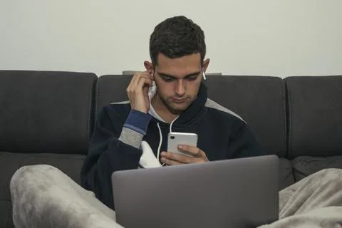 Young man with computer, mobile phone and headphones at home 스톡 사진