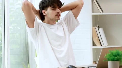 Young man with computer working and relaxing to rest Stock Footage 254012472