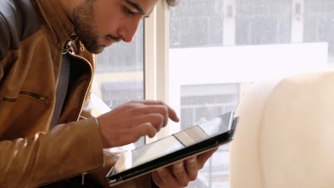 Young man concentrated as he working out a solution to his problem using a touch Stock Footage 101286198