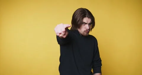 Young man confidently points towards the viewer, creating a dynamic express.. Stock Footage 313280339