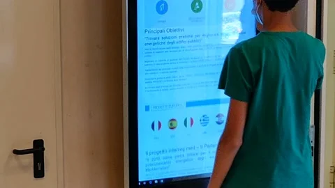 A young man consults information on a touch screen Stock Footage 159394134