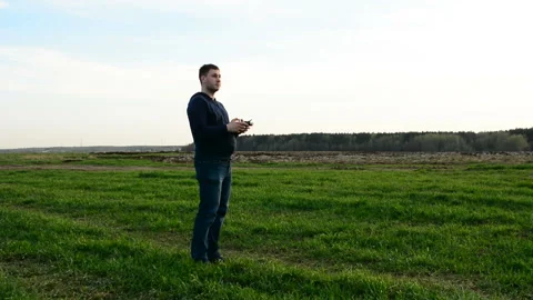 Young man controling drone in field at sunset. Stock Footage 89451503