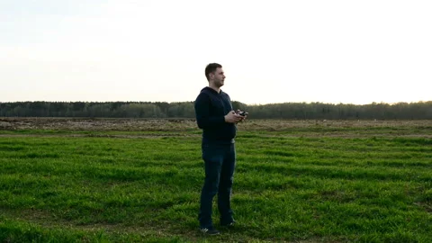 Young man controling drone in field at sunset. Stock Footage 89451675