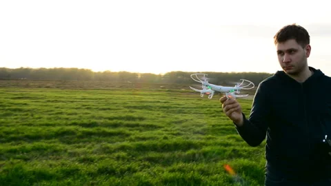 Young man controling drone in field at sunset. Stock Footage 89453020