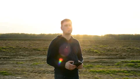 Young man controling drone in field at sunset. Stock Footage 89455980