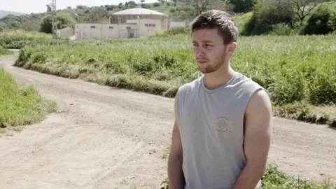 Young man controlling drone standing in the field with a remote his In hands. Stock Footage 116141953