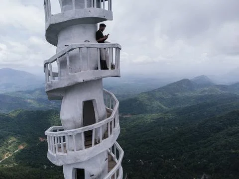Young man controlling drone while enjoying scenic view from white Foto stock