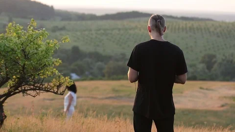 Young man Controlling Quadrocopter drone with Remote Control. Beautiful summe Stock Footage 110708151