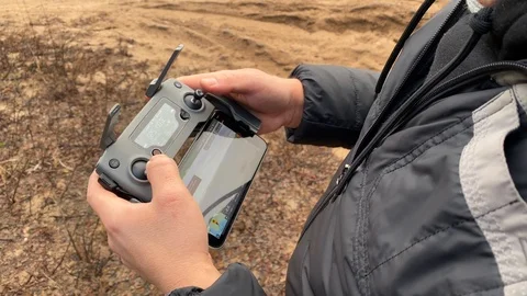 A young man controls a drone through a remote control Stock-Footage 122910602