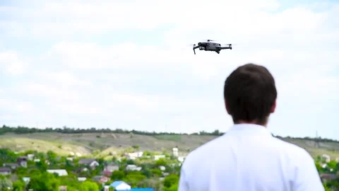 Young man controls a drone using a remote control Stock Footage 310045194