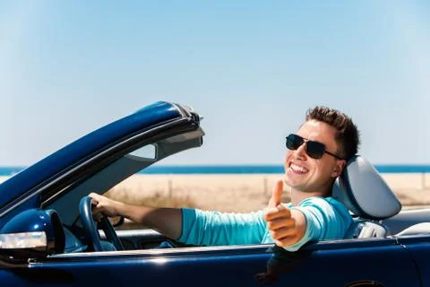 Young man in convertible doing thumbs up. Stock Photos
