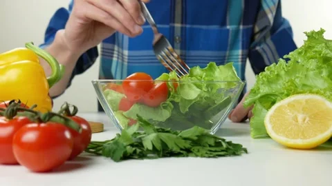 Young man coocking vegetable salad observing diet and counting calories wellness Stock Footage 99625756