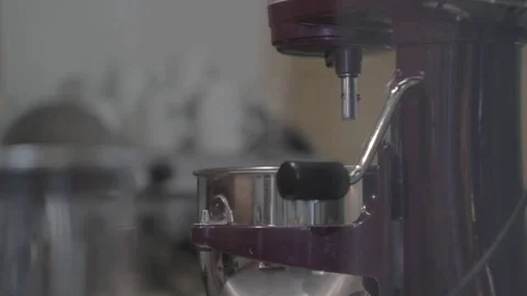 A young man, a cook dresses a corolla, a spatula on a mixermixer. Turns  Stock Footage 74869047