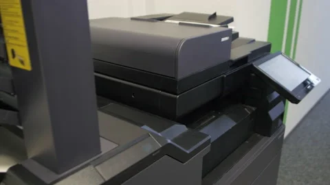 Young man copies documents on a copying system in office Stock-Footage 170754823