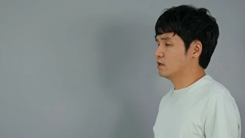 Young Man coughing on gray background with coronavirus symptoms Stock Footage 128536665