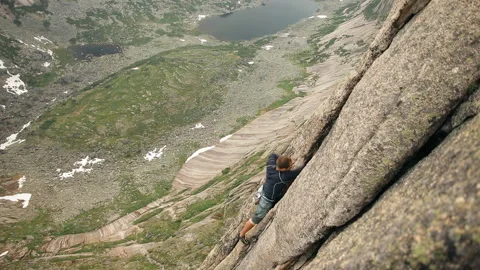 A young man courageously climbing a mountain without a rope. Stock-Footage 92608926