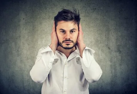 Young man covering ears avoiding noise Stock Photos