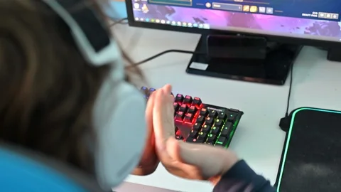 Young man cracking his knuckles while playing a computer game on a backlit gamin Vidéo 127596735
