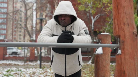 Young Man Cracks Knuckles Resting on Iron Bar in Cold Urban Environment Stock Footage 305628628