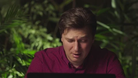 Young man crying while sitting at the computer Stock Footage 149030924