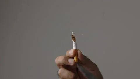 A young man cut a cigarette into two with scissors. He wants to quit smoking for Video stock 152765679