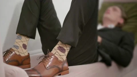 Young man in cute socks and low shoes lying on sofa Video stock 130392235