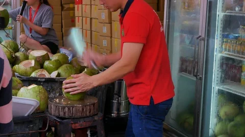 Young Man Cuts Coconuts On The Market In Chinatown, Singapore, Medium Shot Stock Footage 100668338