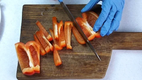 Young man cuts sweet pepper into pieces in kitchen of house. Stock Footage 82160245