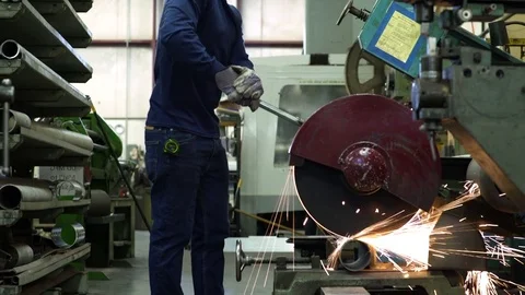 Young man cutting a pipe in a factory Stock Footage 83395140