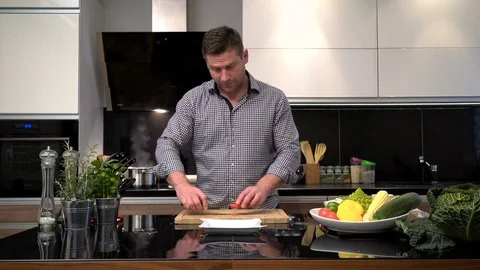 Young man cutting tomatoes. 库存影片 70617308