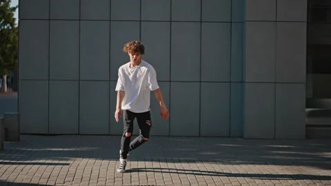 Young man dancer performs quickstep on city street pavement Stock Footage 200223184